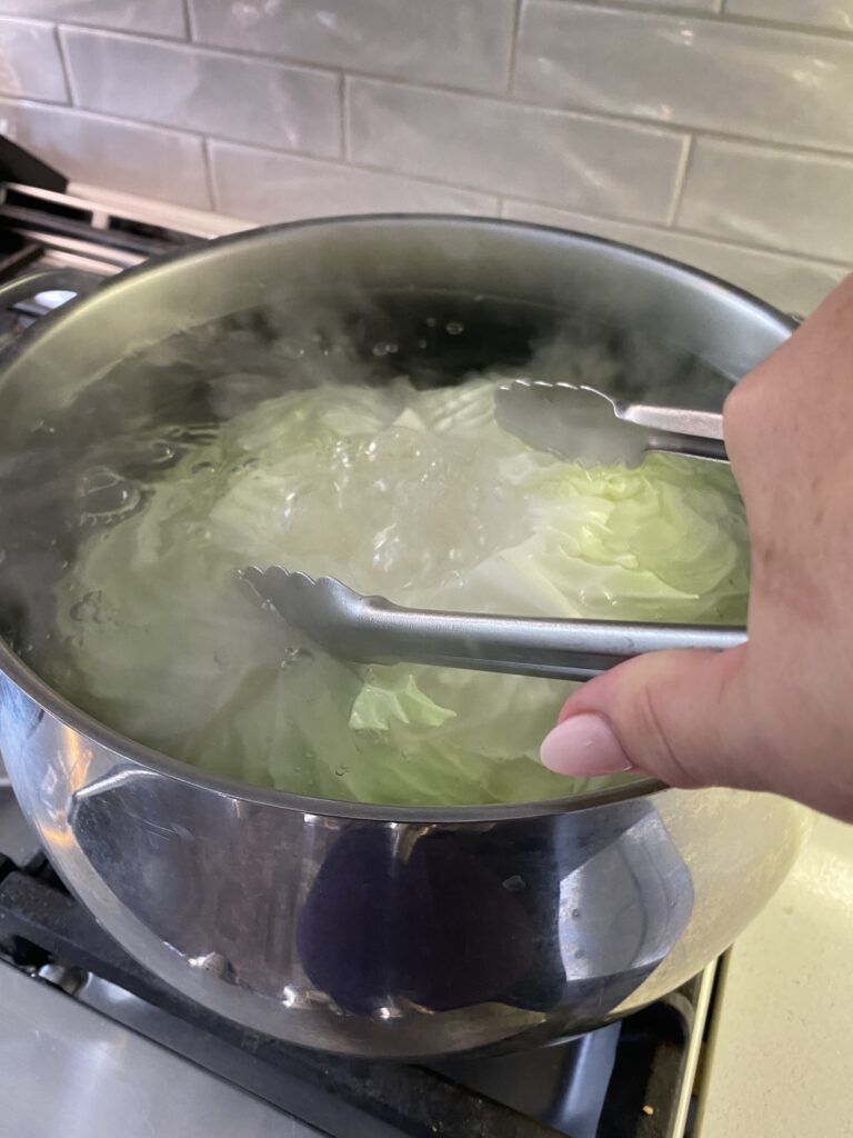 Submerging cabbage to peal off leaves for cabbage rolls