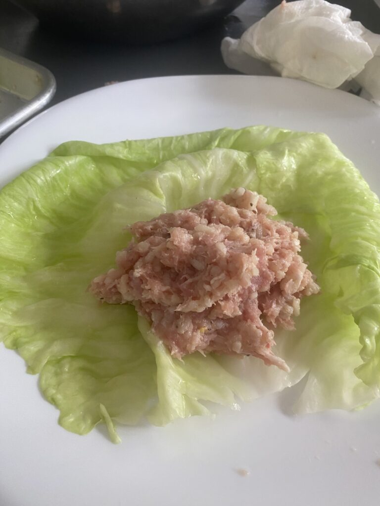 Ground pork and rice filling placed on a prepared cabbage leaf for cabbage rolls